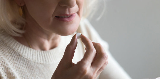 Woman taking a pill.