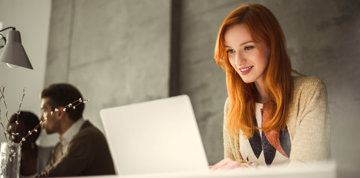 Woman with red hair using a laptop.
