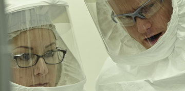 Scientists wearing protective gear.