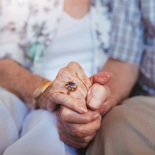 Elderly people holding hands.