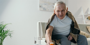 Elderly man taking some medicine.