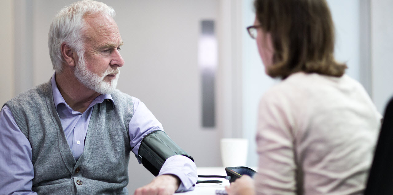 Man getting his blood pressure checked by a professional.