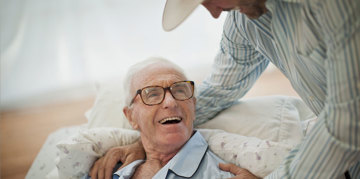 Man supporting an elderly patient.