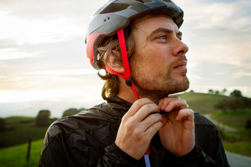 Man tightening his biking helmet