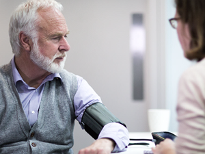 Man getting his blood pressure checked by a professional.