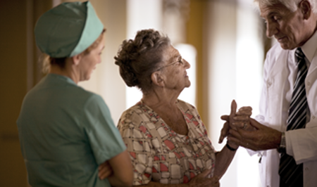 Doctor and nurse speaking with elderly patient.