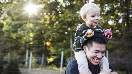 Father carrying his child on his shoulders.