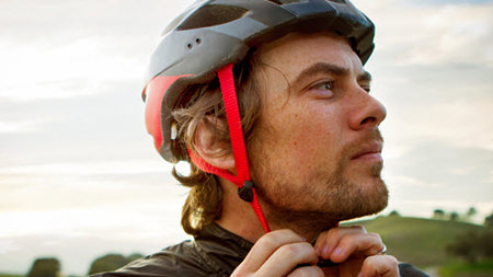 Man tightening bike helmet.