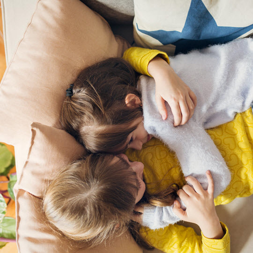 Children hugging on a sofa.