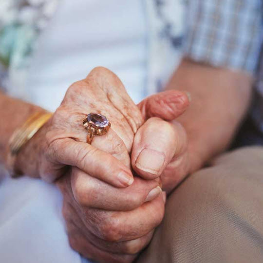 Elderly people holding hands.