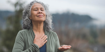 Woman taking a breath outdoors.