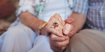 Elderly people holding hands
