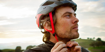 Man tightening biking helmet.