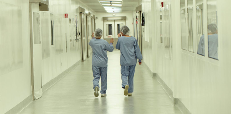 Two nurses walking down a hall