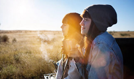 Girls drinking coffee outdoors.